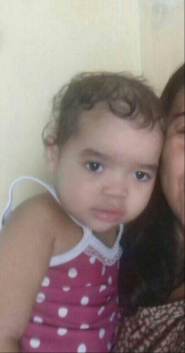 A menina tem 1 ano e 8 meses e pele morena