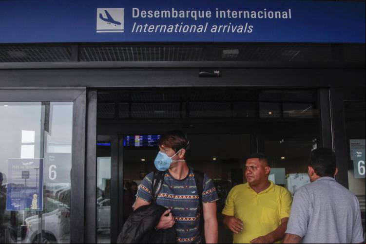 Movimentação de ageiros e funcionários no aeroporto internacional de Fortaleza usando máscaras por prevenção ao coronavírus.