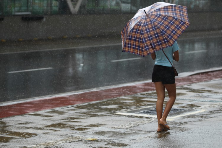 Pessoas andando com guarda chuva durante manhã chuvosa