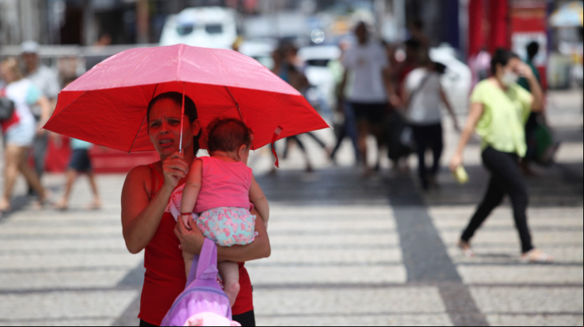 As temperaturas máximas devem variar entre 32 graus Celsius ( °C) e 36 °C em grande parte do Estado até esta quarta-feira, 21. Em Fortaleza, são esperados números em torno de 32â¯°C. Na imagem, mulher se protege do sol na Praça do Ferreira, na Capital, em 2023 