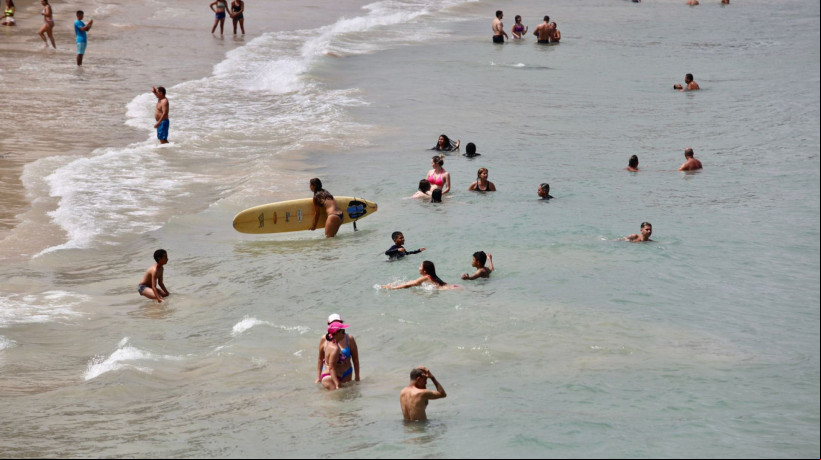 Mesmo imprópria para banho de mar, Praia dos Crush tem surfistas, turistas e famílias com crianças na manhã de Natal