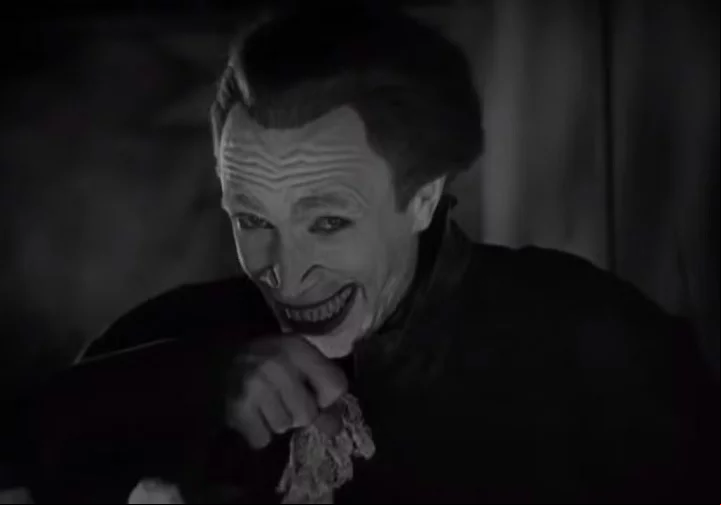 Como punição pelo erro do pai, o rosto de Gwynplaine é deformado, deixando um sorriso permanente em sua face.
