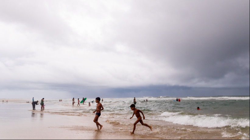 Foliões e turistas foram à praia em Fortaleza mesmo em meio a chuva. Carnaval 2025 está sendo marcado por precipitações características da quadra chuvosa