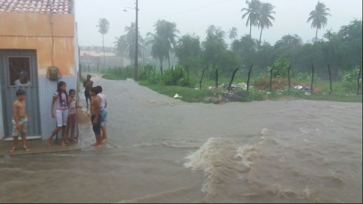Imagem de pessoas observando rua alagada 